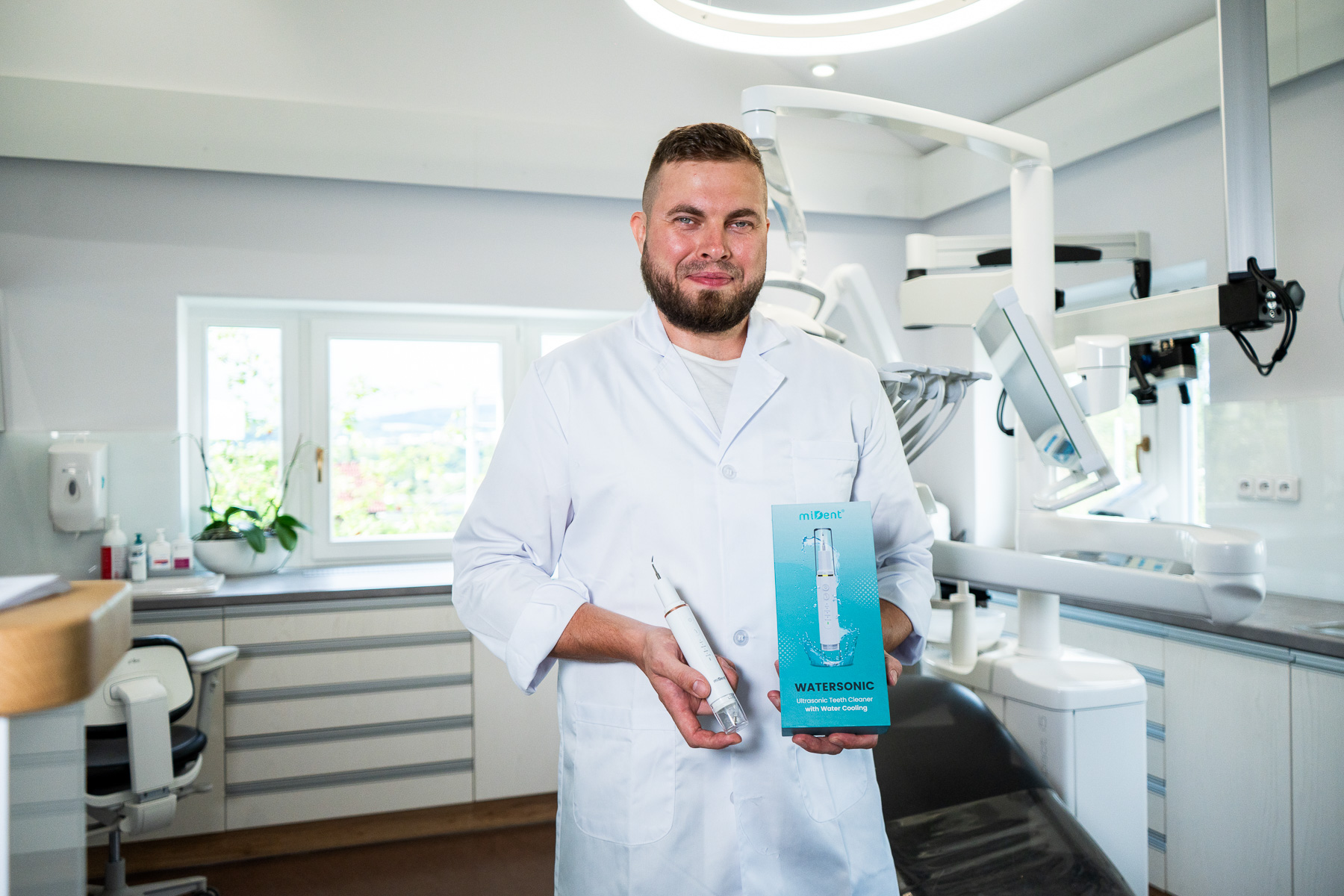 Fachperson mit WaterSonic und Verpackung in der Praxis